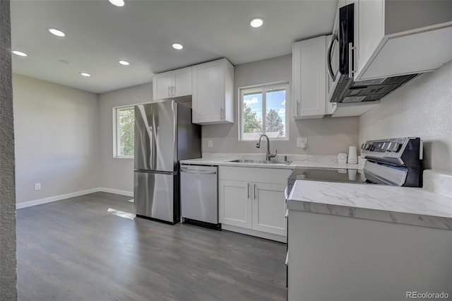 kitchen with appliances with stainless steel finishes, dark hardwood / wood-style flooring, sink, and white cabinets