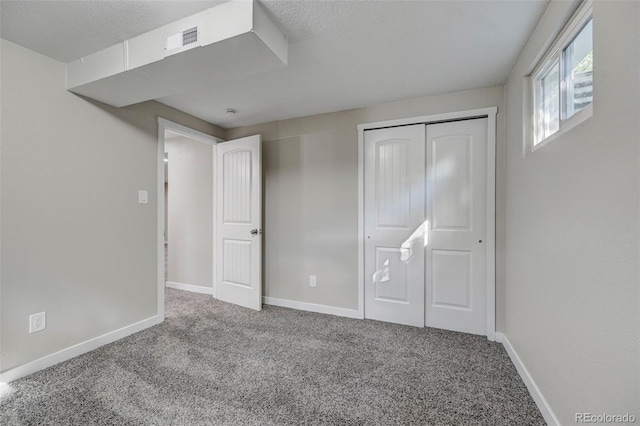 unfurnished bedroom with a closet, a textured ceiling, and carpet