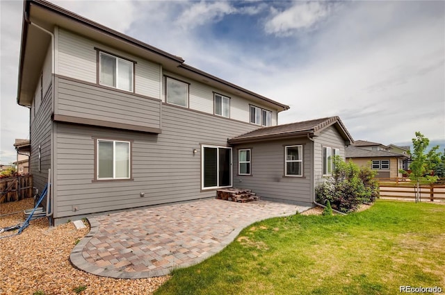 rear view of property featuring a yard and a patio