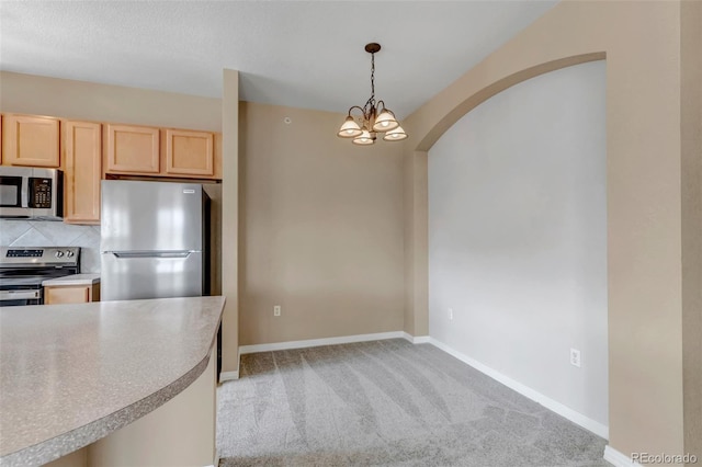 9387 Ashbury Cir Unit 203, Parker, CO 80134 - kitchen with appliances with stainless steel finishes, light brown cabinets, light colored carpet, and arched walkways