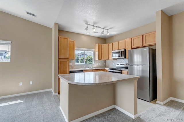 9387 Ashbury Cir Unit 203, Parker, CO 80134 - kitchen with stainless steel appliances, light countertops, decorative backsplash, a center island, and light carpet