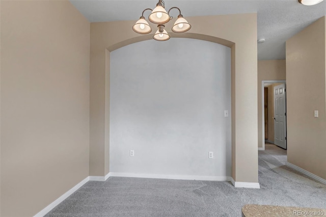 9387 Ashbury Cir Unit 203, Parker, CO 80134 - carpeted empty room featuring arched walkways and a chandelier