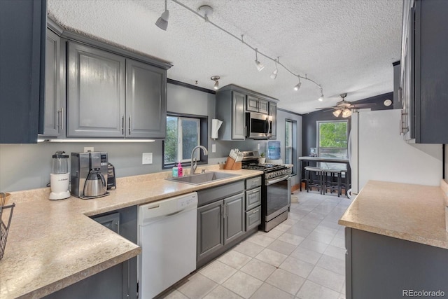 110 Evans Ave, Poncha Springs, CO 81242 - kitchen with appliances with stainless steel finishes, light tile patterned flooring, a ceiling fan, a textured ceiling, and gray cabinetry