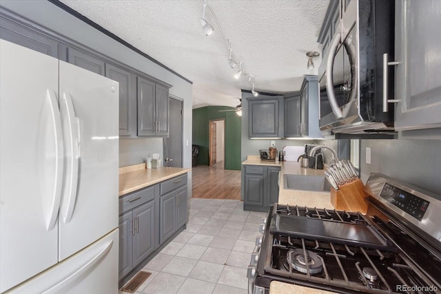 110 Evans Ave, Poncha Springs, CO 81242 - kitchen featuring stainless steel appliances, gray cabinetry, light countertops, rail lighting, and a textured ceiling