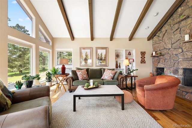 1555 Genesee Ridge Rd, Golden, CO 80401 - living area featuring wood finished floors, beamed ceiling, plenty of natural light, a stone fireplace, and high vaulted ceiling