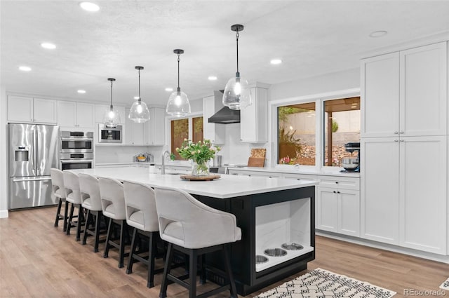 9939 E Aberdeen Ave, Englewood, CO 80111 - kitchen featuring stainless steel appliances, a sink, light countertops, recessed lighting, and a center island with sink