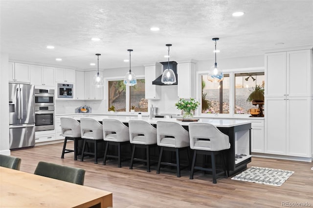 9939 E Aberdeen Ave, Englewood, CO 80111 - kitchen with stainless steel appliances, recessed lighting, light countertops, white cabinets, and an island with sink