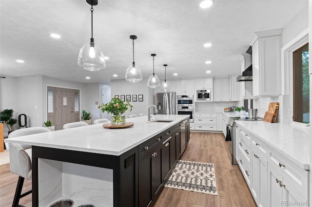 9939 E Aberdeen Ave, Englewood, CO 80111 - kitchen with stainless steel appliances, a sink, a breakfast bar, white cabinetry, and dark cabinetry