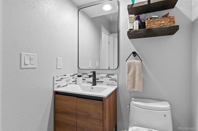 9939 E Aberdeen Ave, Englewood, CO 80111 - bathroom with vanity, toilet, tasteful backsplash, and a textured wall
