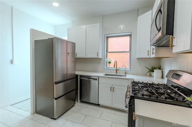 kitchen with decorative backsplash, stainless steel appliances, light countertops, white cabinetry, and a sink