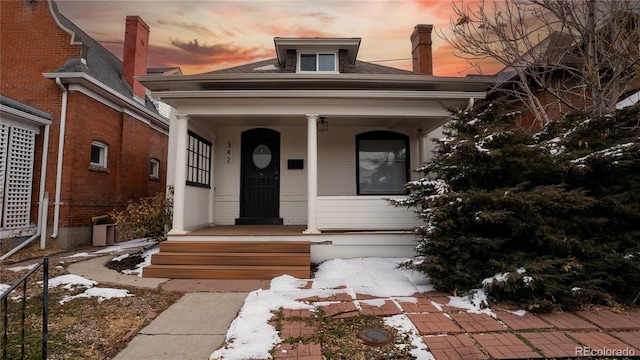 view of front of house featuring a shingled roof and brick siding