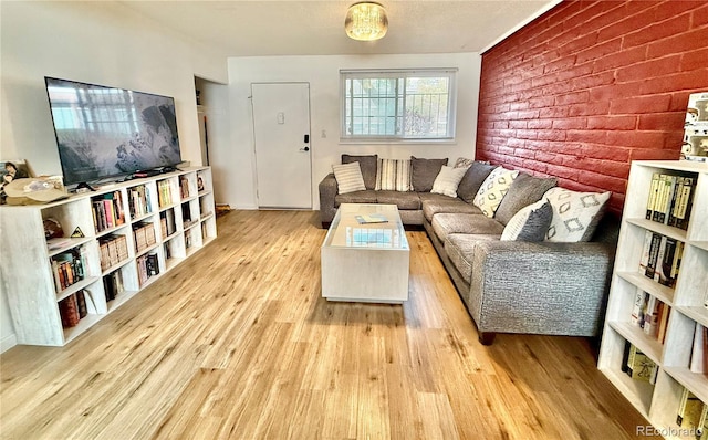 living room with brick wall and wood finished floors