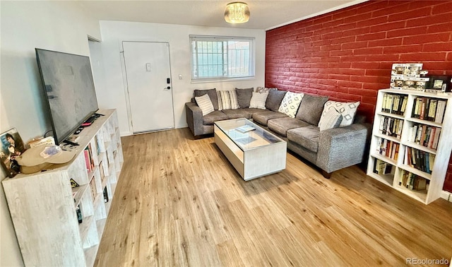 living room with light wood-style floors and brick wall