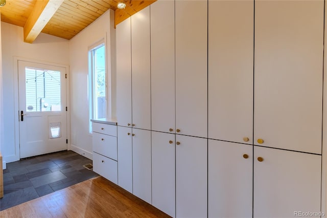 entryway with vaulted ceiling with beams, dark hardwood / wood-style floors, and wooden ceiling