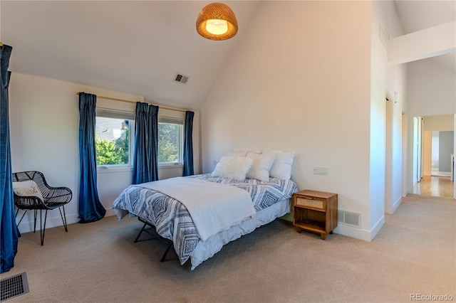 bedroom with light carpet and high vaulted ceiling