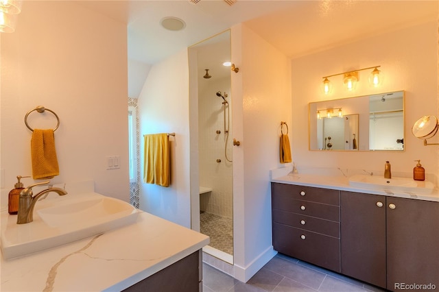 bathroom with tiled shower, vanity, tile patterned floors, and lofted ceiling