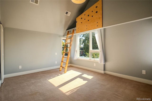 spare room with light colored carpet and high vaulted ceiling