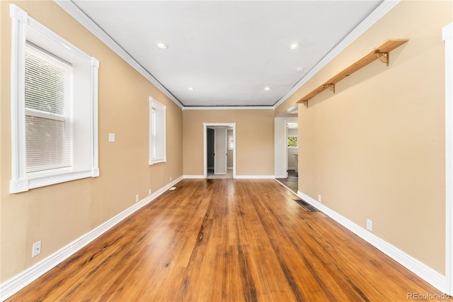 empty room featuring hardwood / wood-style floors and crown molding