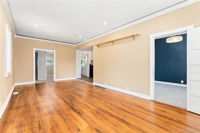 spare room featuring hardwood / wood-style flooring and ornamental molding