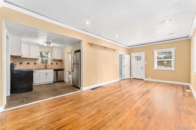 unfurnished living room with sink, light wood-type flooring, and crown molding