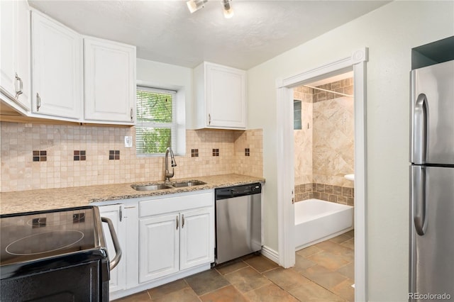 kitchen featuring light stone countertops, sink, white cabinetry, and stainless steel appliances