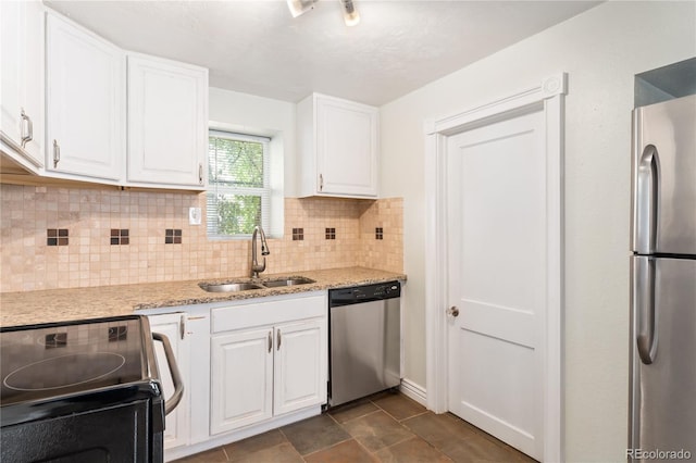 kitchen with light stone countertops, backsplash, stainless steel appliances, sink, and white cabinetry