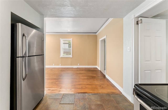 kitchen featuring stainless steel refrigerator and crown molding