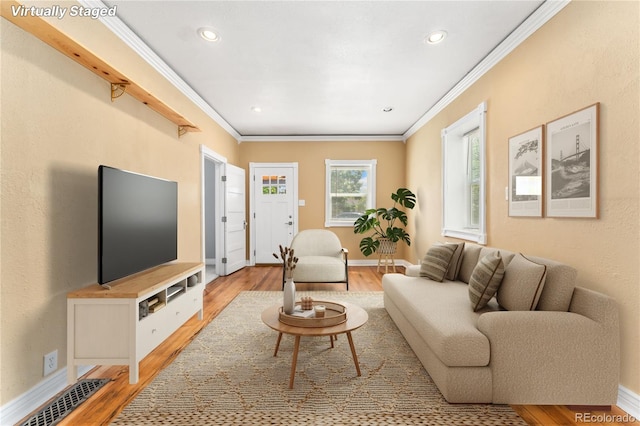 living room with ornamental molding and light hardwood / wood-style flooring