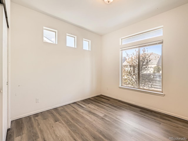 empty room with plenty of natural light and dark hardwood / wood-style floors