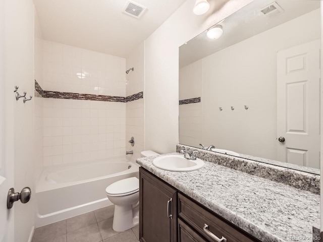 full bathroom with tile patterned flooring, vanity, tiled shower / bath combo, and toilet