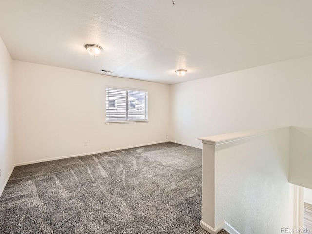 empty room featuring dark colored carpet