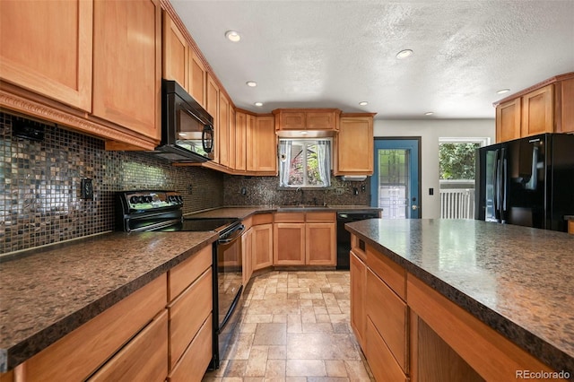 8679 Apache Plume Dr, Parker, CO 80134 - kitchen with black appliances, dark countertops, backsplash, a sink, and stone tile floors