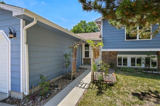 8679 Apache Plume Dr, Parker, CO 80134 - view of exterior entry with a lawn and roof with shingles