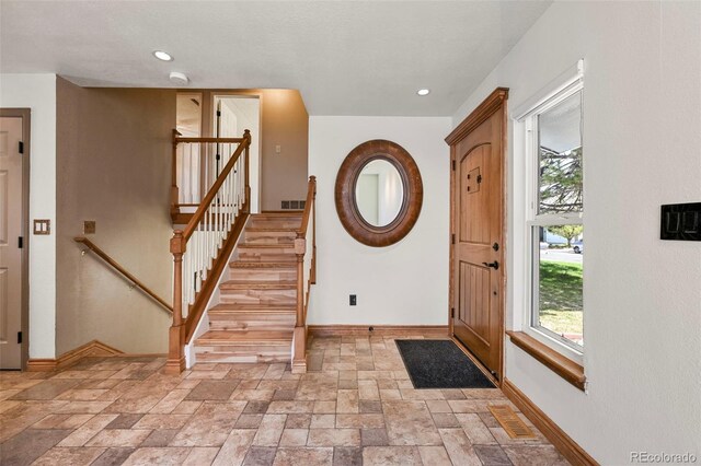 8679 Apache Plume Dr, Parker, CO 80134 - entryway featuring baseboards, stone tile flooring, stairway, and recessed lighting