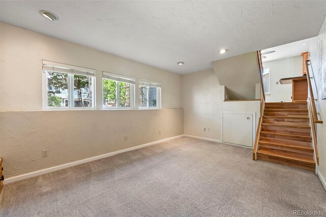 8679 Apache Plume Dr, Parker, CO 80134 - unfurnished living room with carpet, stairs, baseboards, a textured wall, and recessed lighting