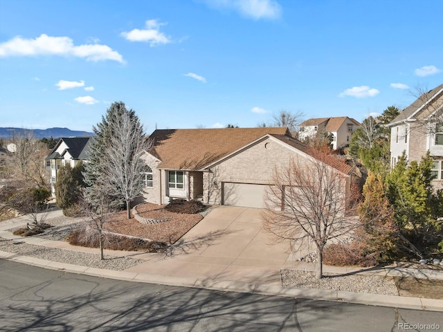 view of front of property with driveway, an attached garage, a mountain view, and stucco siding