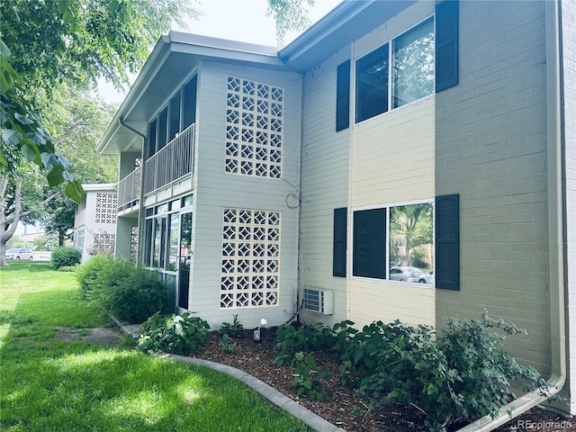 exterior space with central AC and a lawn