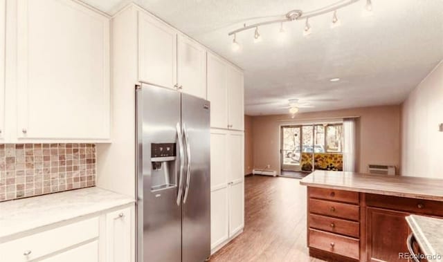 kitchen with white cabinets, stainless steel fridge with ice dispenser, light hardwood / wood-style flooring, and tasteful backsplash