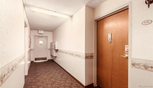 hall with a textured ceiling