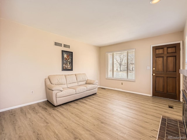 unfurnished living room with baseboards, visible vents, and light wood-style floors