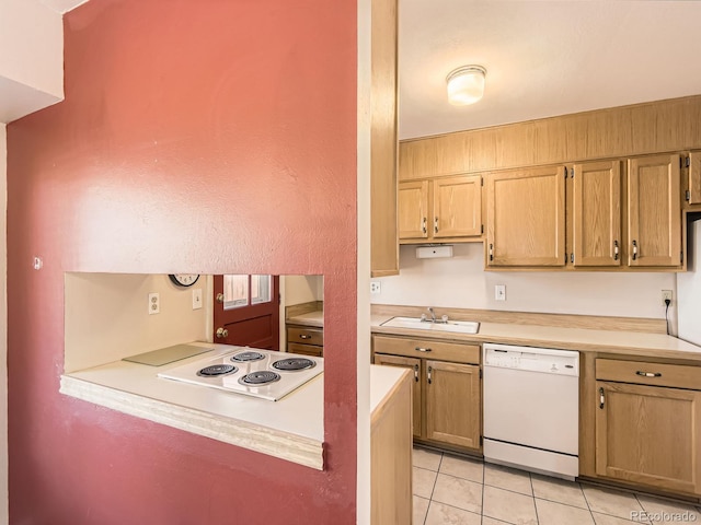 kitchen featuring light tile patterned floors, light countertops, white appliances, and a sink