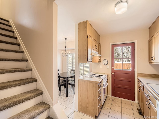 kitchen featuring hanging light fixtures, light countertops, white electric range, under cabinet range hood, and a chandelier