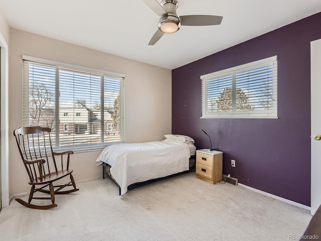 bedroom with light colored carpet, ceiling fan, and baseboards