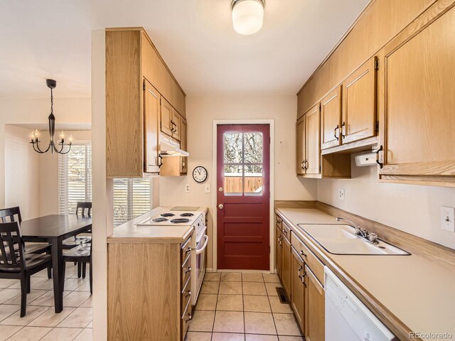 kitchen with white appliances, decorative light fixtures, light countertops, under cabinet range hood, and a sink