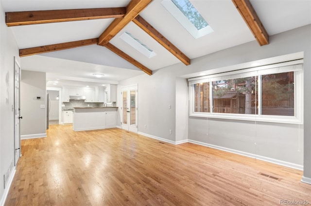 8132 Lodgepole Trl, Lone Tree, CO 80124 - unfurnished living room with plenty of natural light, visible vents, baseboards, light wood finished floors, and lofted ceiling with skylight