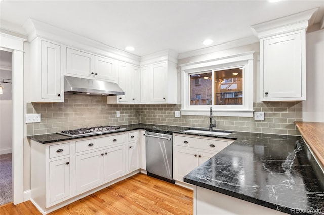 8132 Lodgepole Trl, Lone Tree, CO 80124 - kitchen with light wood-type flooring, under cabinet range hood, white cabinets, a sink, and stainless steel appliances