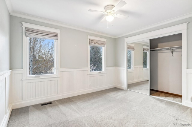8132 Lodgepole Trl, Lone Tree, CO 80124 - unfurnished bedroom featuring visible vents, crown molding, a wainscoted wall, a closet, and carpet