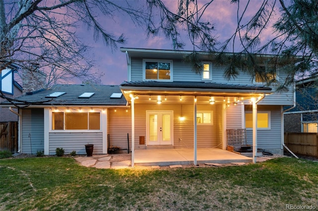 8132 Lodgepole Trl, Lone Tree, CO 80124 - back of property at dusk featuring fence, a lawn, and a patio area