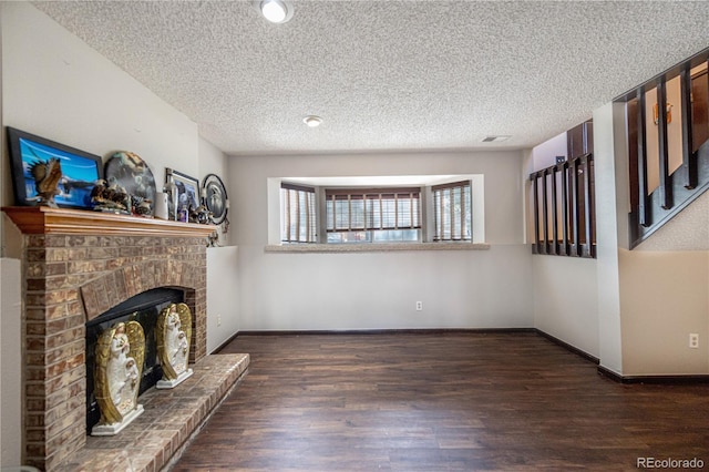 4362 Nepal St, Denver, CO 80249 - unfurnished living room with wood finished floors, a brick fireplace, and a textured ceiling