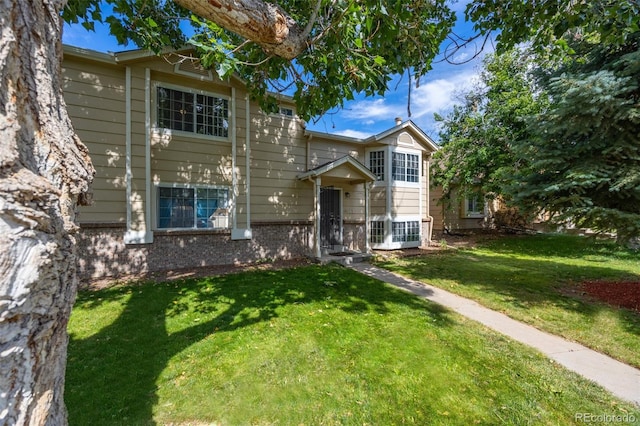 4362 Nepal St, Denver, CO 80249 - traditional home featuring a front lawn and brick siding